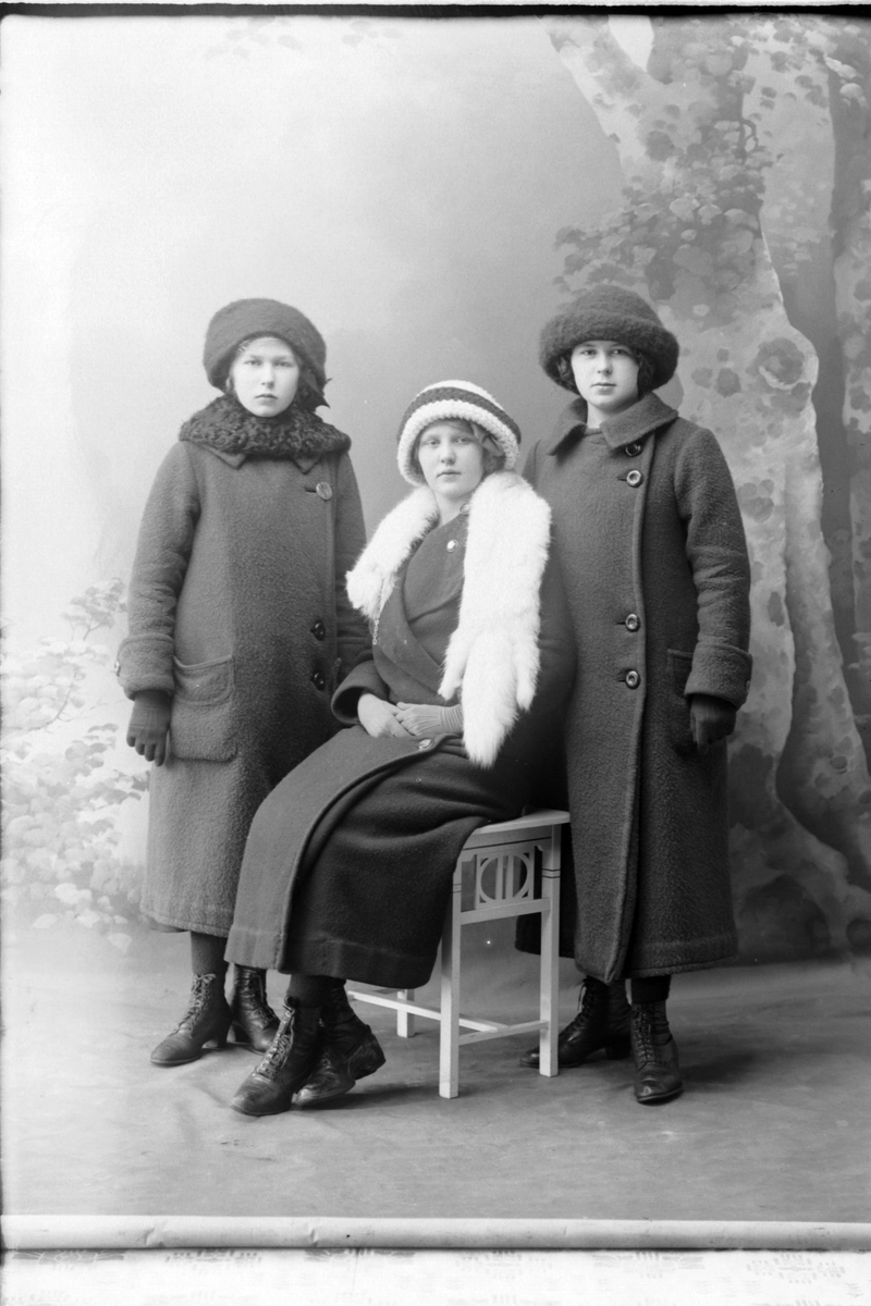 Studioportrett av tre vinterkledde kvinner.