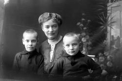 Studioportrett av en kvinne med to barn.