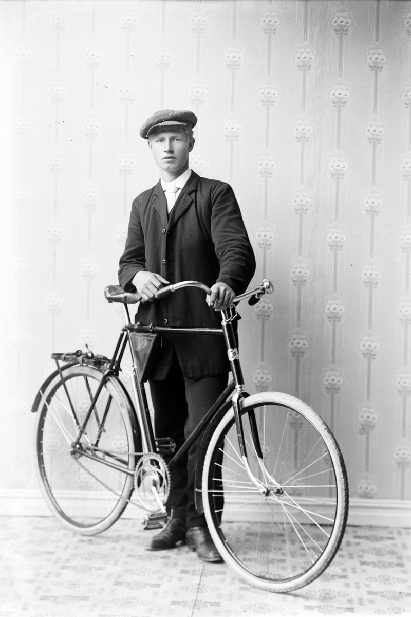 Studioportrett av en mann med en sykkel.