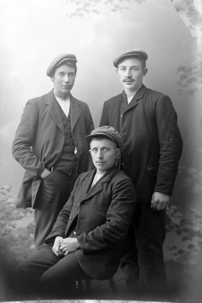 Studioportrett av tre menn.