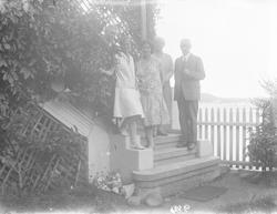 En mann og fire kvinner på trappen utenfor Lyng Olsens hus i