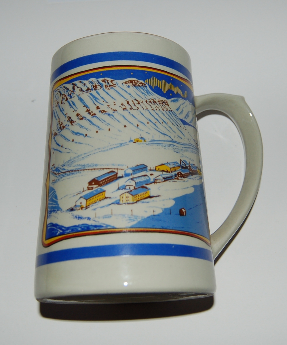 Utsmykka kjegleformet souvenirkrus i glassert porselen.
Motiv: Gruvesamfunn. Isbjørn på isflak.
Tekst: Longyearbyen - Svalbard.