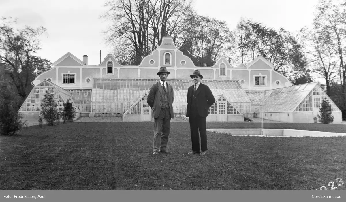 Två män i kostym och hatt står framför växthusen på Julita i Södermanland.