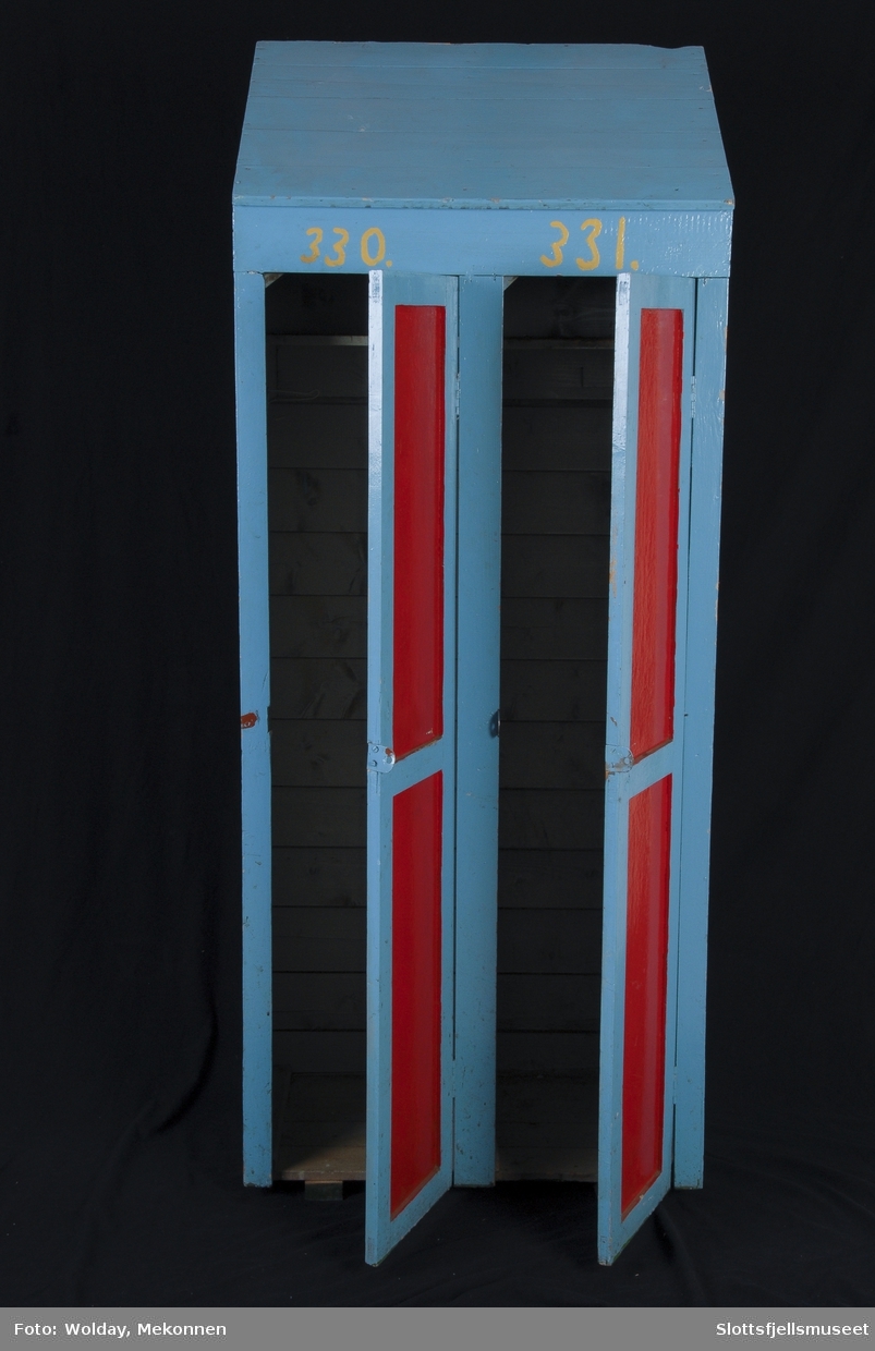 Skap i tre, blåmalt med røde speil i dørene. 
