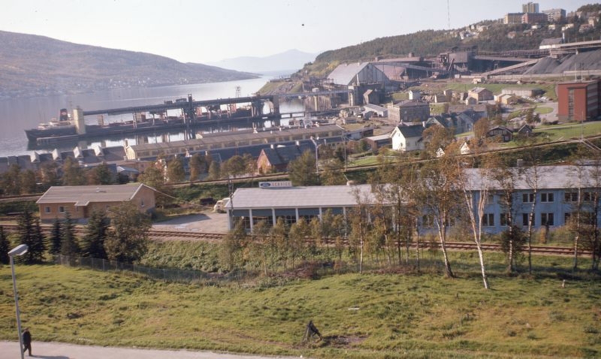 Narvik, LKABs område, malmskip ved kai 3 Narvik Havn, Sjøbakken forrang, jernbane mot Fagernes, Speidernes Hus t.v. og Gunnar Sommerseth's bilverkested i mitten.