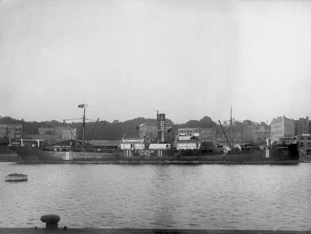 Dampskipet D/S "Fjordheim" ved havn i en muligens britisk by. "Fjordheim" ble omdøpt til D/S "Dicto" da det ble oppkjøpt av rederiet B. Stolt-Nielsen i 1915, og således ble hjemmehørende i Haugesund. Lasteskip.