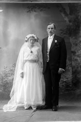 Studioportrett av et brudepar i helfigur.