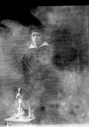 Studioportrett av en mann i matrosdress og en hund.