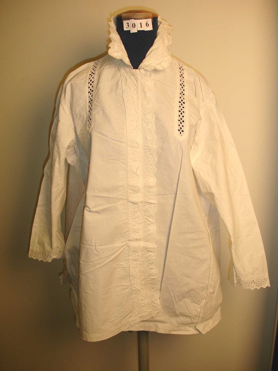 Skjorte, bluse i hvit bomullstoff, Hullmønstret i fronten og nederst på ermene, Rysjer i halsen og langs frontkantene. 