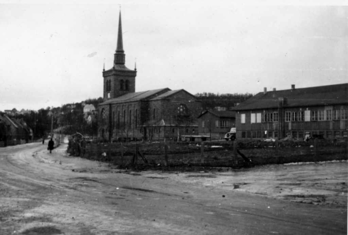 Narvik kirke med brakker. Brakkene i forgrunnen var under krigen tysk  Soldathjem. Etter 1945 ble den kalt "Håkonshallen" og var i flere år både kino og teatersal. I tillegg var det noen leiligheter i bygget.
