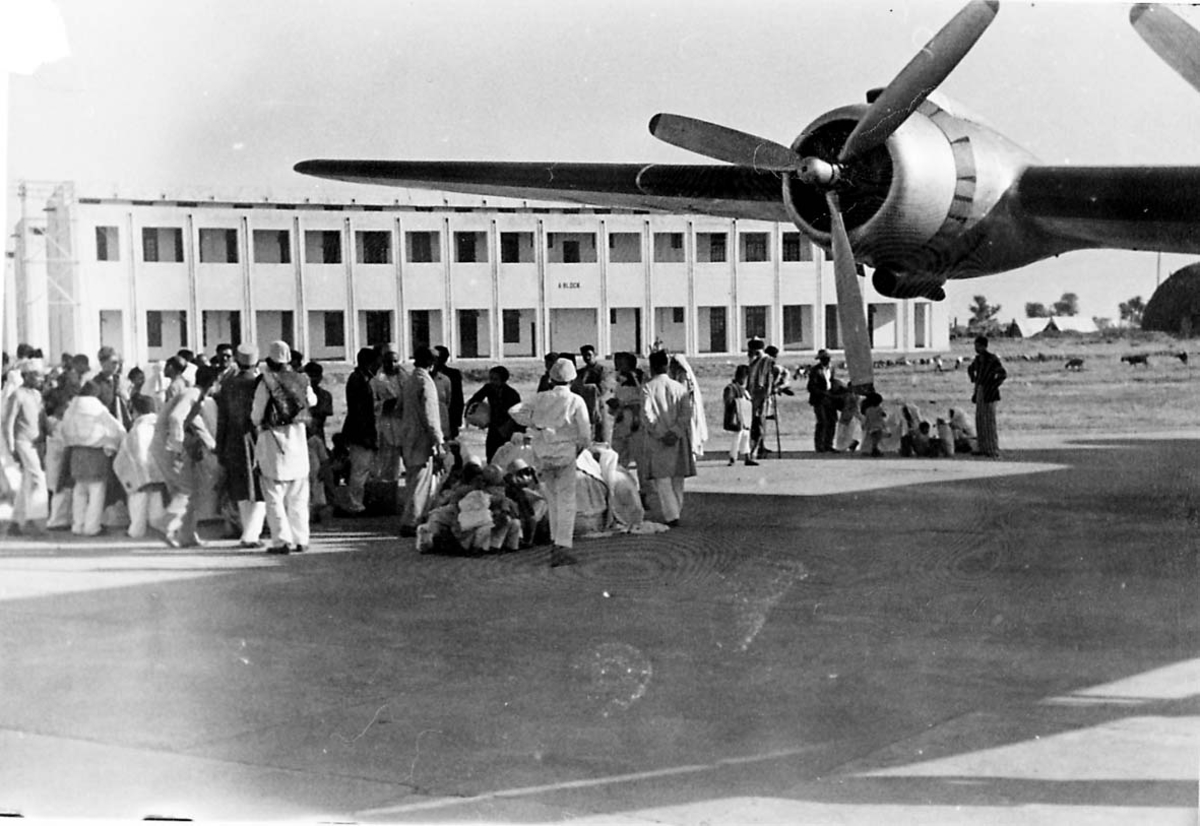 Lufthavn. 1 fly på bakken, Douglas DC-4 C-54 Skymaster fra Braathens SAFE. Flere personer ved flyet