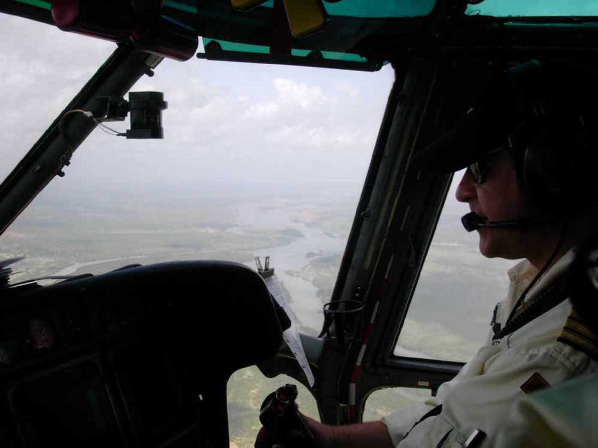 En person, flyger (pilot) inne i flycockpit.