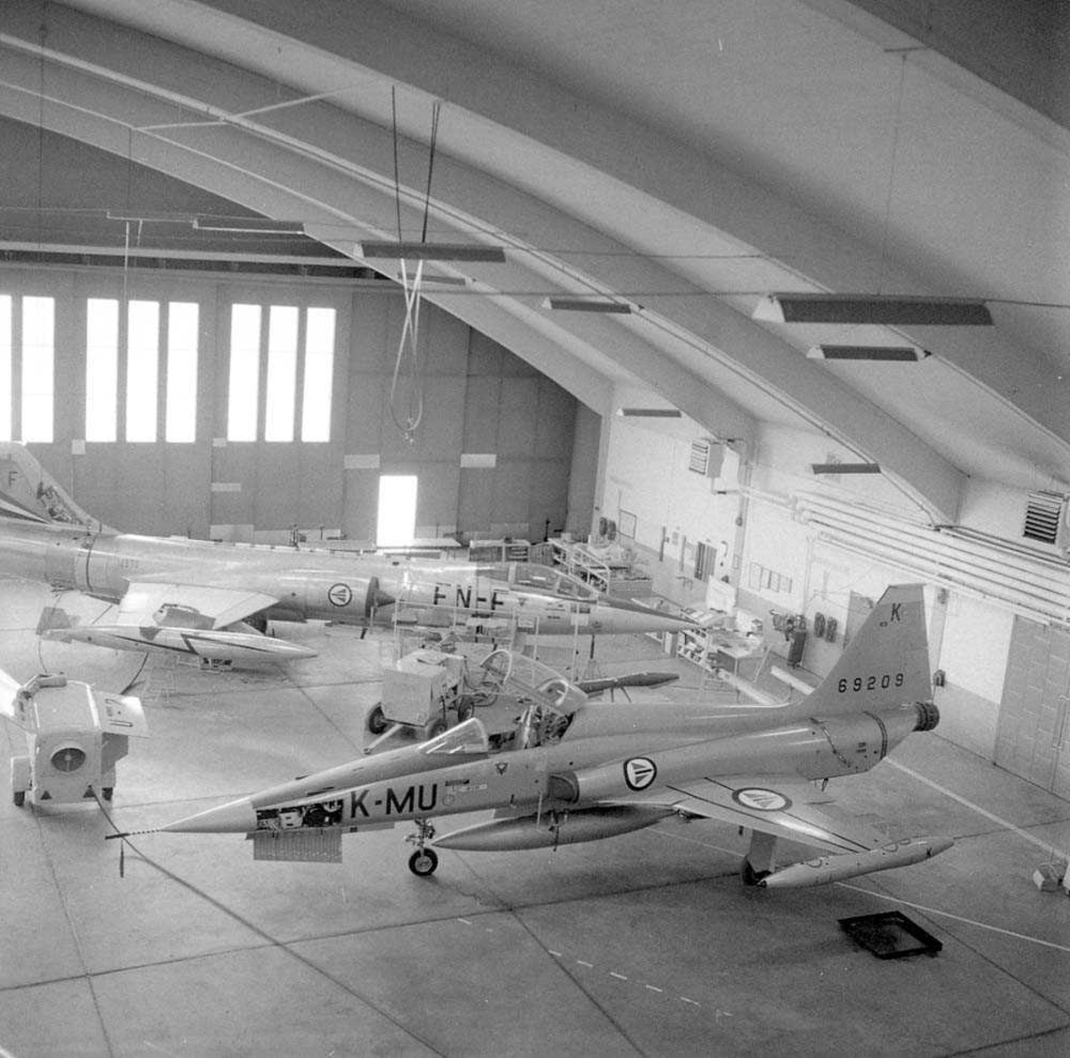 Her i Hangar A sees den første Freedomsfighter F-5-A som er til ettersyn på Bodø flystasjon. Jagerflyet har kjennetegn MU-K og serie nr. 69209. I bakgrunnen sees en  F-104-G Starfighter med kjennetegn FN-F og serie nr. 12630.