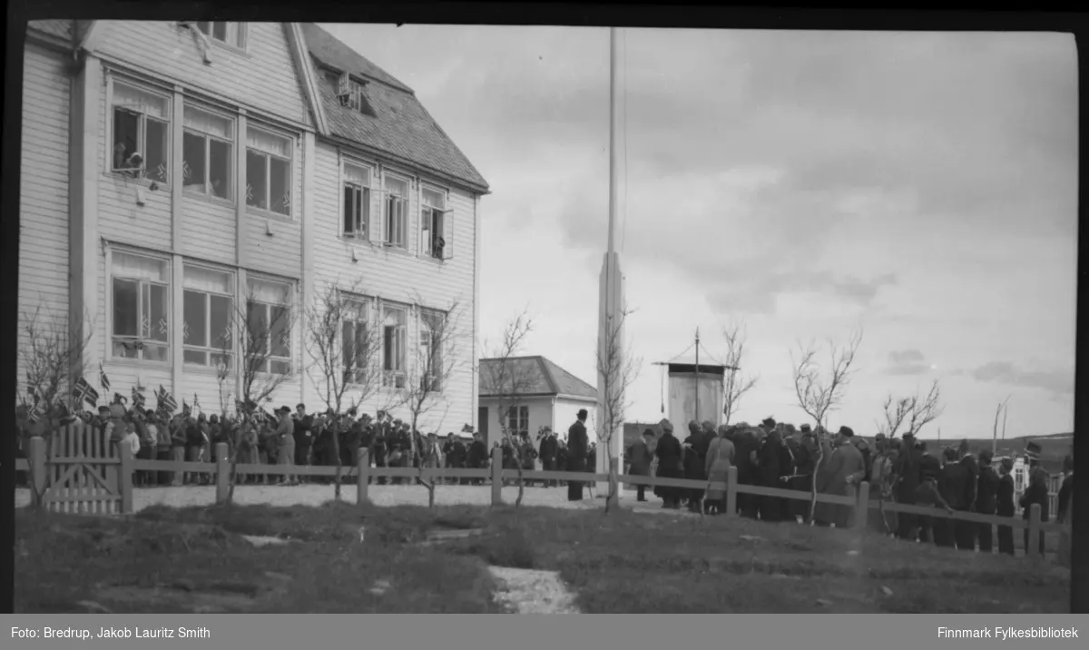 17. mai-feiring i Vadsø.  Barnetoget samlet i hagen foran Statens kysthospital, også kalt skrufolosehospitalet, i Hvistendahlsgate.  Pasientene henger ut av vinduene og vifter med flagg.