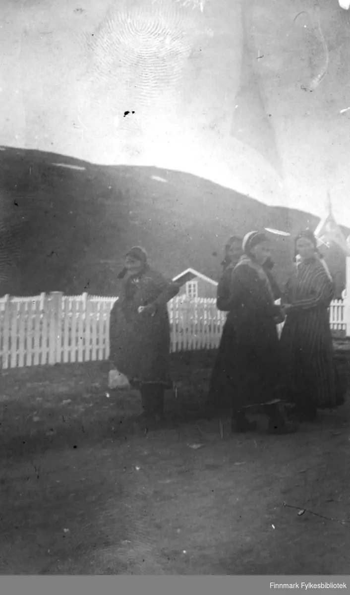 Fire samiske kvinner fotografert utenfor kirka på Langnes i Tana i 1916. Originalbildet var svært bleket, så den digitale kopien er noe utydelig