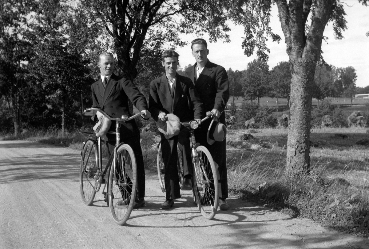Tre män med två cyklar på en väg utanför Jönköping. Mannen till höger heter Gustav Svensson.
