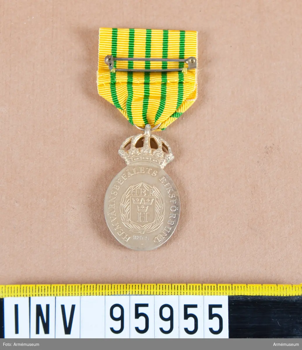 Hemvärnsbefälets riksförbunds kungliga medalj i silver (oval), 8:e storleken.

Band: gult med fem jämt fördelade smala gröna ränder.