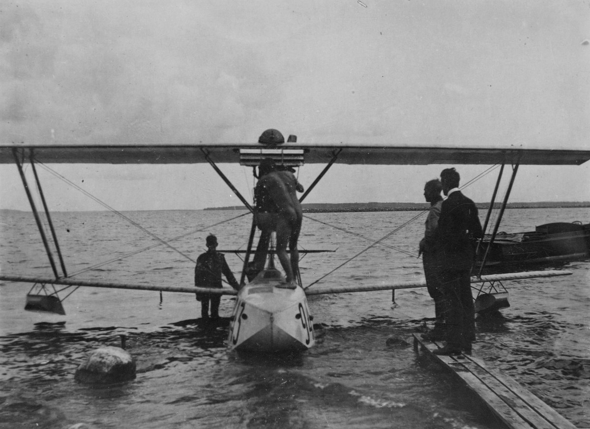 Flygplan Macchi M.7 märkt nummer 943 på sjön Roxen vid Bergs slussar.  Fyra män vid flygplanet.