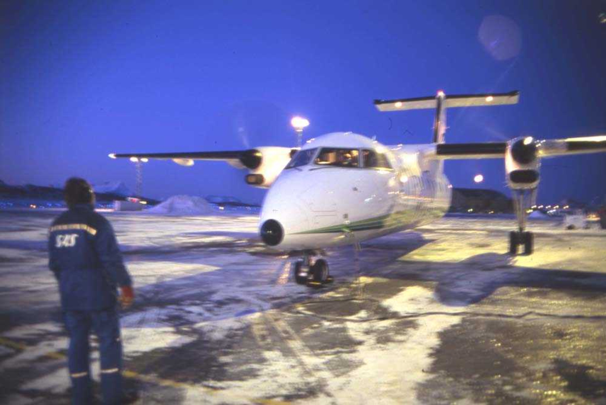 Lufthavn/Flyplass. Bodø. Et fly, DHC-8 /Dash8 fra Widerøe starter opp. Marshall fra SAS hjelper til med oppstart.