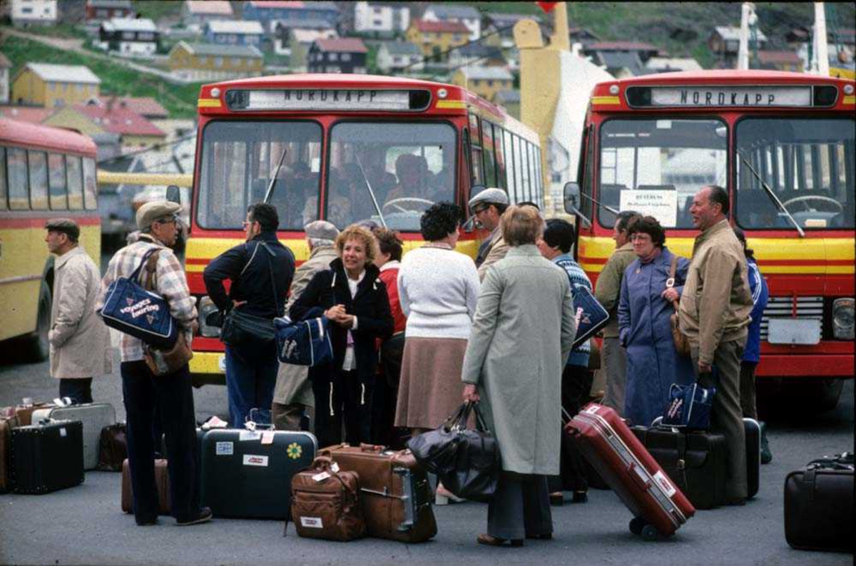 Landskap. Honningsvåg rutebilstasjon. Turister venter på tur til Nordkapp.