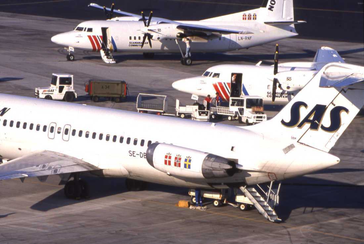 Lufthavn - flyplass. Bodø nye Lufthavn. Et knippe med SAS-fly står parkert ved den gamle flyterminalen. En DC-9 og to Fokker 50..