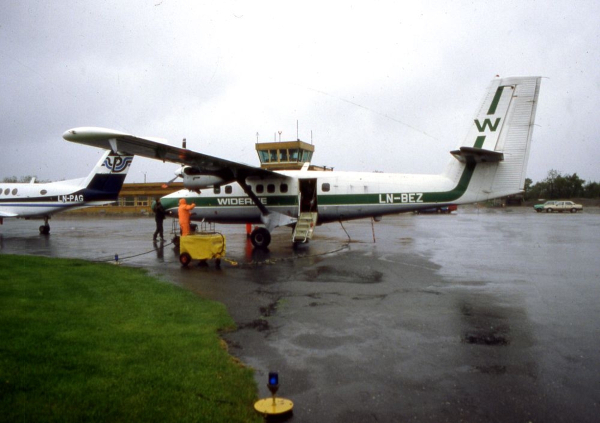 Lufthavn (flyplass). To fly, LN-BEZ, DHC-6-300 Twin Otter fra Widerøe og LN-PAG, Beech Super King Air fra Partnair. To personer på oppstillingsplassen (tarmac).