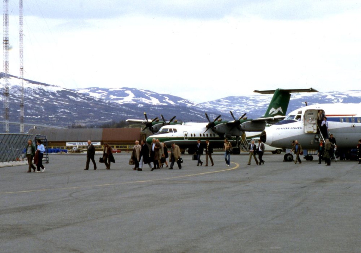 Lufthavn (flyplass). To fly, DHC-7-201 Dash 7 fra Widerøe og en DC9 fra SAS parkert. Passasjerer forlater SAS flyet på vei mot flyterminalen. I bakgrunn skimtes Norving hangar.