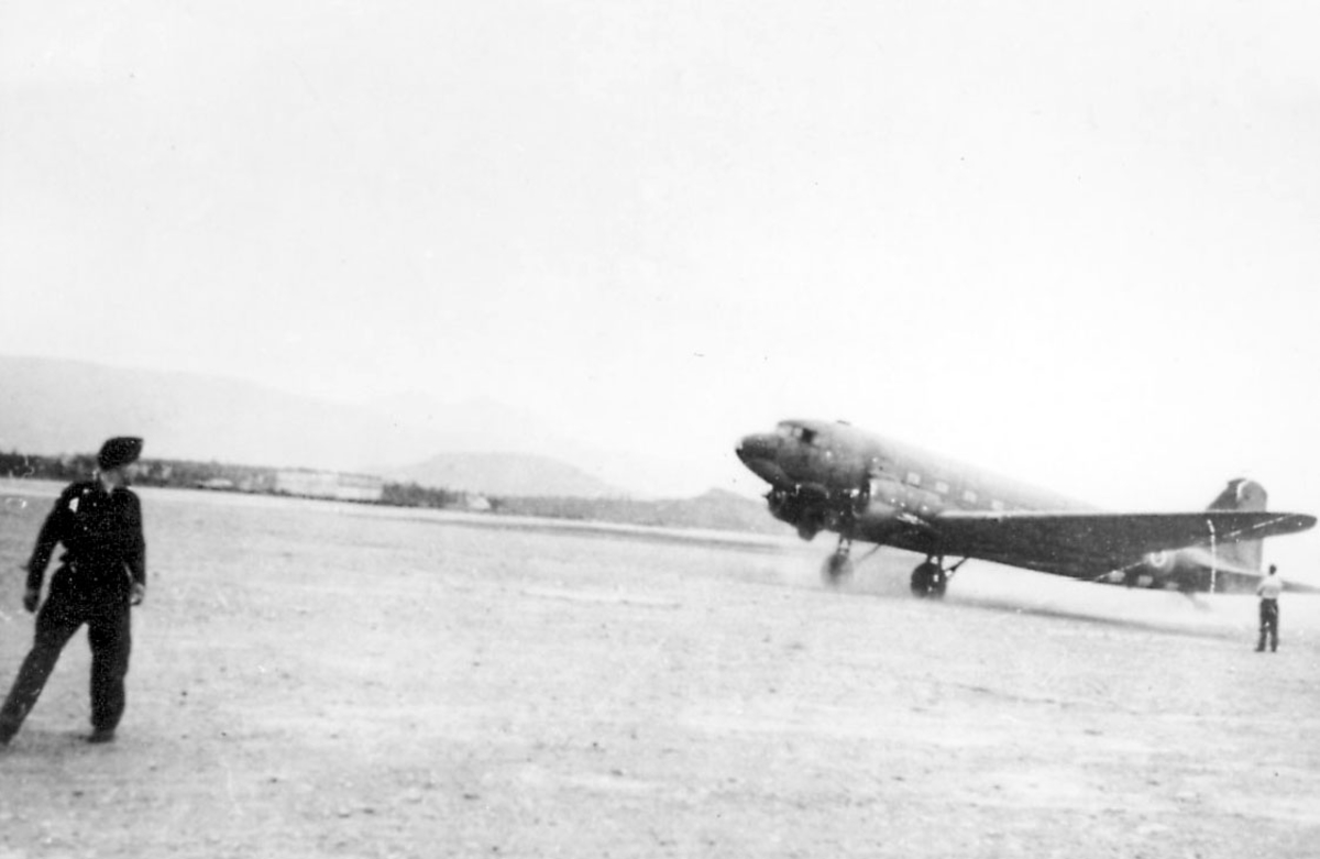 Lufthavn (flyplass), ett fly på bakken, Douglas C47 DC-3) Dakota. to personer foran flyet.