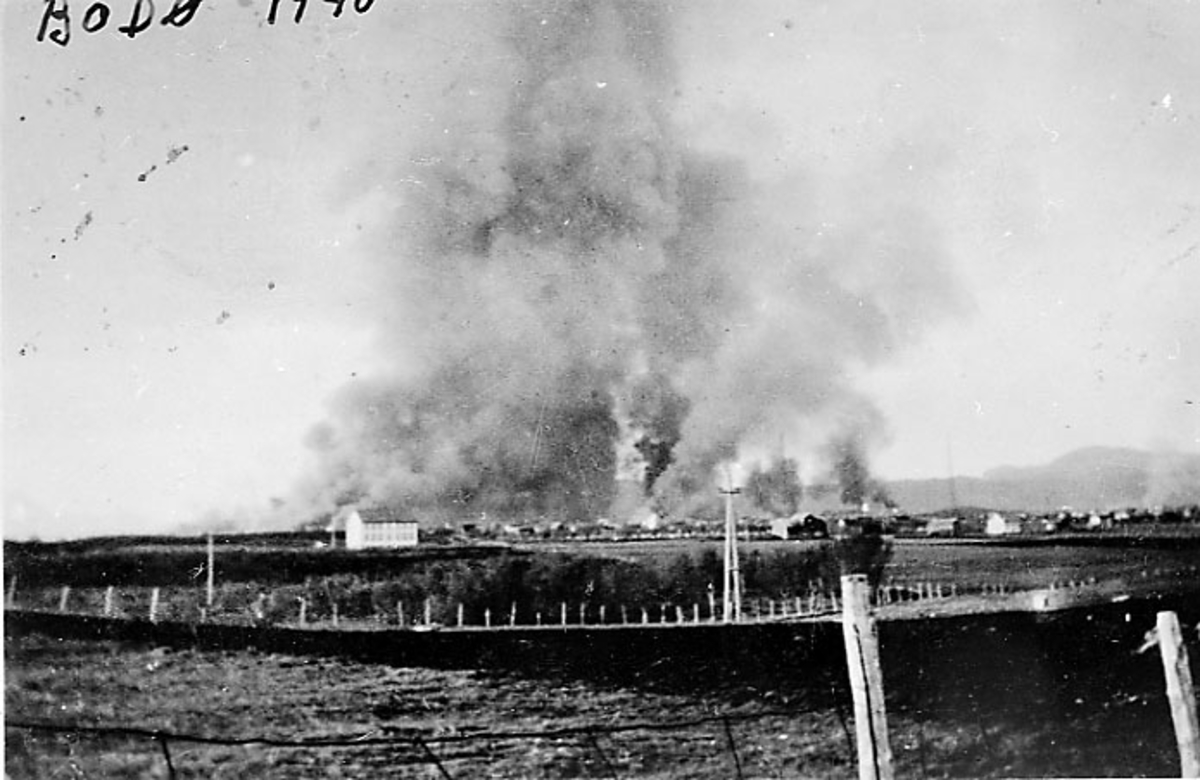 Bodø i brann etter bombingen under 2. verdenskrig, sett fra Hernes. Jorder i forgrunnen.