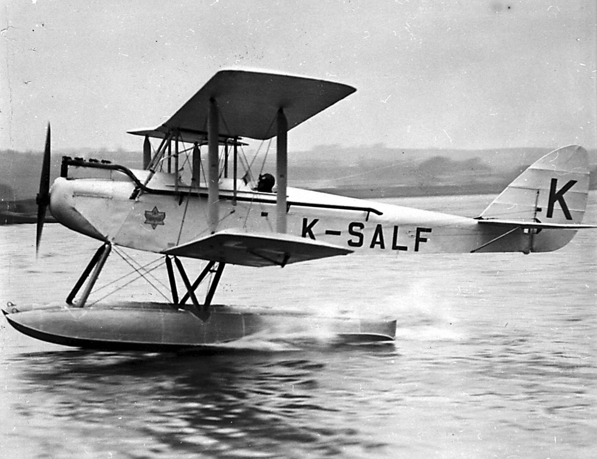 1 fly på vannet i fart med 1 person, pilot i cockpit, DH-60 Moth fra Harstad Lufttrafikk A/S.