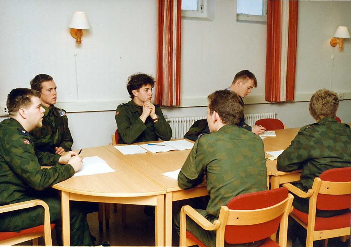 Gruppe.  Seks soldater sitter ved et bord.