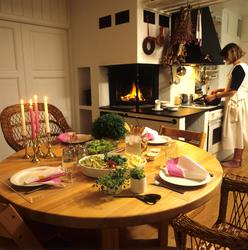 Kjøkken med peis. Dekket middagsbord hvor det serveres pasta