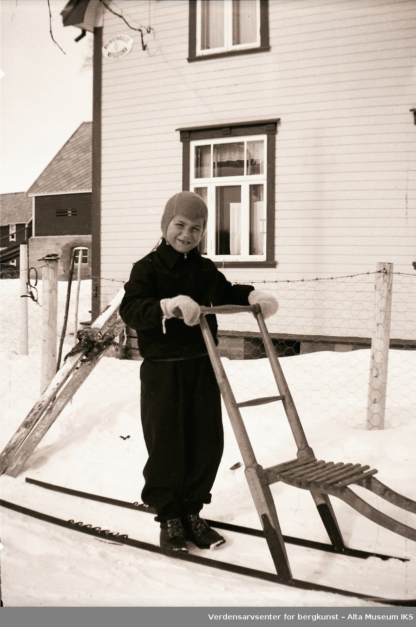 Gutt i vinterklær på spark utenfor huset på Jøraholmen, rundt 1936.