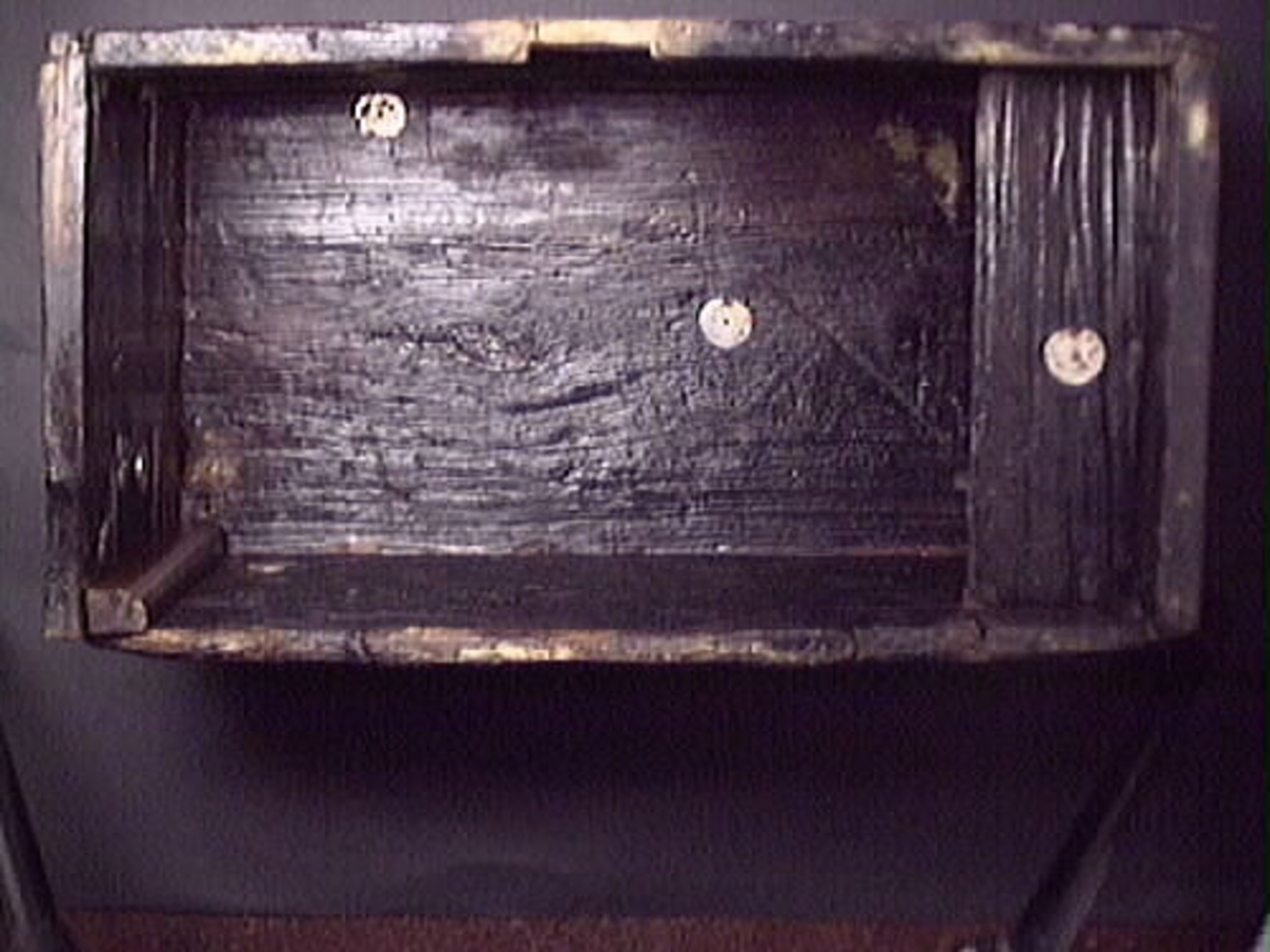 En kista.
Kistan består av totalt nio delar, varav tre delar ej är monterade. Kistans sidor och botten är ihopfogade med träplugg. Bakstycket och framstycket har falsade kanter. Gavlarnas kanter är snedskurna för inpassning mot bak- och framstyckets fals. Kistan har ursprungligen varit försedd med lås, gångjärn och handtag av järn.
På insidan av kistans framstycke, fyndnummer 14207, finns ett urtag för låset. Urtaget är ca 9 mm djupt. I det övre högra hörnet finns ett spår för läddikan. Läddikan har varit placerad längs med kistans vänstra gavel. På utsidan av framstycket finns hål efter ett trekantigt bleck. Ett längsgående, triangelformat parti av famstyckets nedre del saknas. Det saknade stycket är ersatt med en nytillverkad träbit om 365x64 mm. På framstyckets vänstra  sida, vid skarven mot gaveln, saknas två mindre partier om ca 30x30 mm.
Gavel, fyndnummer 14209. Ett parti av gavelns nedre del saknas. Det saknade stycket är ersatt med en nytillverkad träbit om 45x 295 mm. I skarven mot baksidan saknas ett ytligt, långsmalt parti av gaveln.
Gavel, fyndnummer 14210. På utsidan mitt finns två små spikhål efter ett handtagsbeslag. Ett ytligt parti om ca 70x30 mm av gavelns nedre hörn saknas. Gavelns yta är ojämn.

Bakstycke, fyndnummer 08593. Bakstyckets övre hörn är något rundade. I ovankant finns två urtag för gångjärnen. På bakstyckets insida finns spår efter läddikan. Bakstyckets yta är ojämn.
Kistbotten, fyndnummer 14212. Delar av bottnens hörn och kanter saknas. Bottnens undersida är grov och ojämn.
Kistlock, fyndnummer 14213. På lockets undersida, längs med kortsidorna, sitter lister för att hålla locket på plats. Listerna har avfasade kanter och vardera list är fästad med tre tränaglar. Locket och listerna minskar i tjocklek mot den bakre långsidan. På insidan av locket insida, strax innanför ytterkanten, finns ett trekantigt urtag för låset. På lockets ovansida syns spår efter gångjärnsbeslag. Mindre partier av lockets bakre del saknas. En ca 85 mm lång bit av höger list saknas.
Läddika, fyndnummer 14226. Läddikan består av en rak bräda som vilar på två nytillverkade lister. Läddikan är i gott skick.
Kistan är sliten. Delar av kistan försågs med ett nytt lager av polyetylenglykol av konserveringsenheten, april 1996.