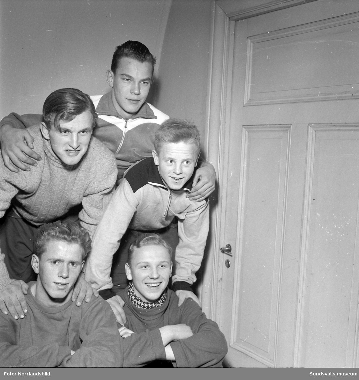 Gruppbild av fem unga brottare i Bordtennislokalen, före detta 125:an, vid Storgatan 41.
