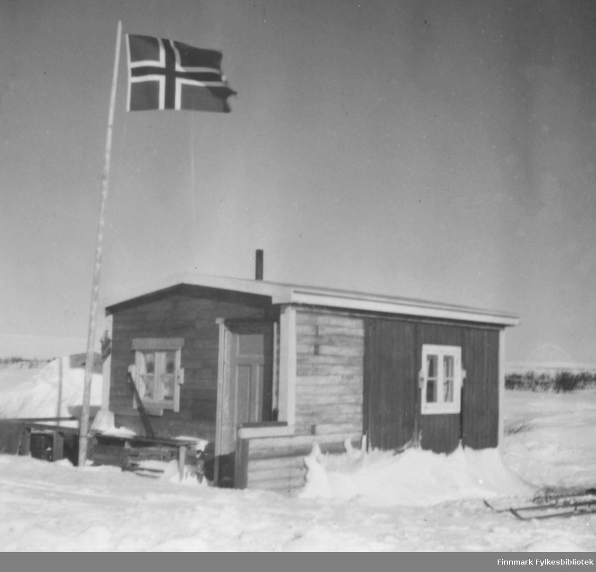 Hytte ved Sjåbuselva i Vadsø. Den tilhørte Edith og Arne Berg, Ragnhilds tante og onkel. Flagget er heist, ski i snøen ved hytta