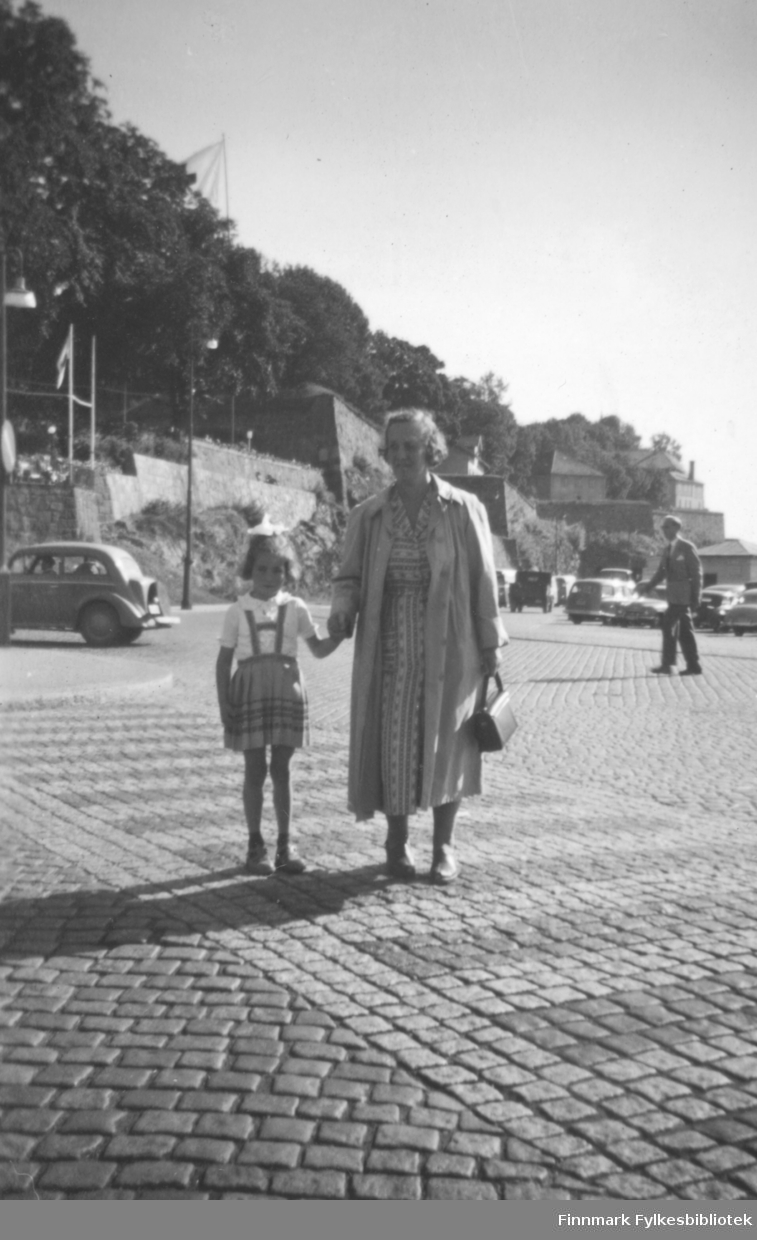 Torill Ebeltoft på ferie i Oslo i 1955. Her leier hun sin grandtante Lillemor. I bakgrunnen ser vi Akershus festning