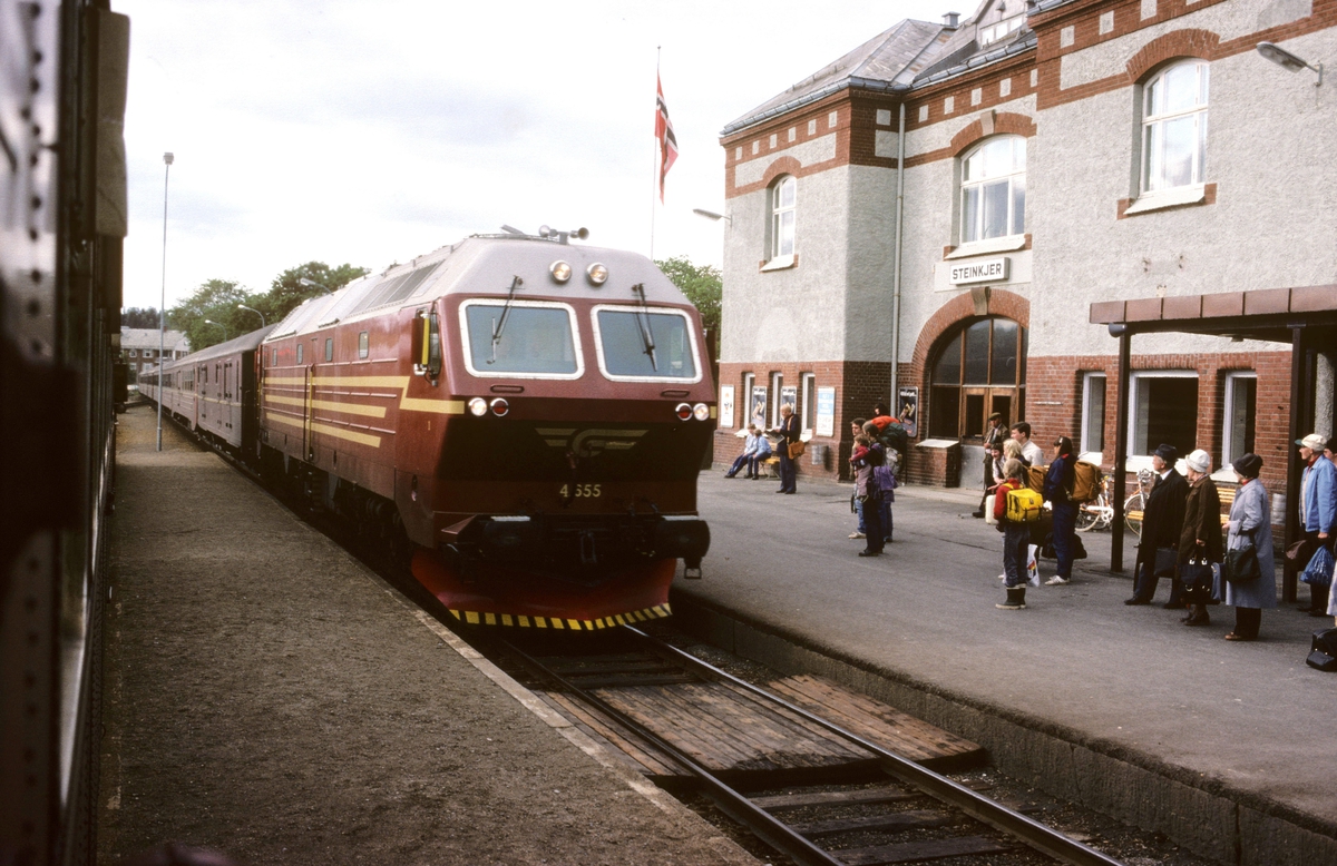 Sørgående dagtog på Nordlandsbanen, hurtigtog 452, ankommer Steinkjer med dieselelektrisk lokomotiv Di 4 655. Bildet er tatt fra kryssende tog, persontog 457 til Grong med dieselmotorvogn type 86.