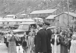 Kong Haakon den syvende blant spente tilskuere, midt i brakk