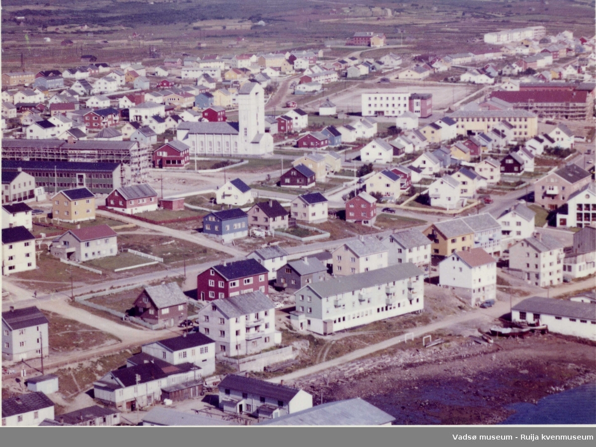 Flyfoto av Vadsø, 1963. Midtbyen sett fra sørvest. Takene i nedre billedkant er husene på Samvirkekaia.