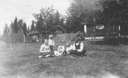 Fotografi av en mann, en kvinne og tre barn som sitter på ba