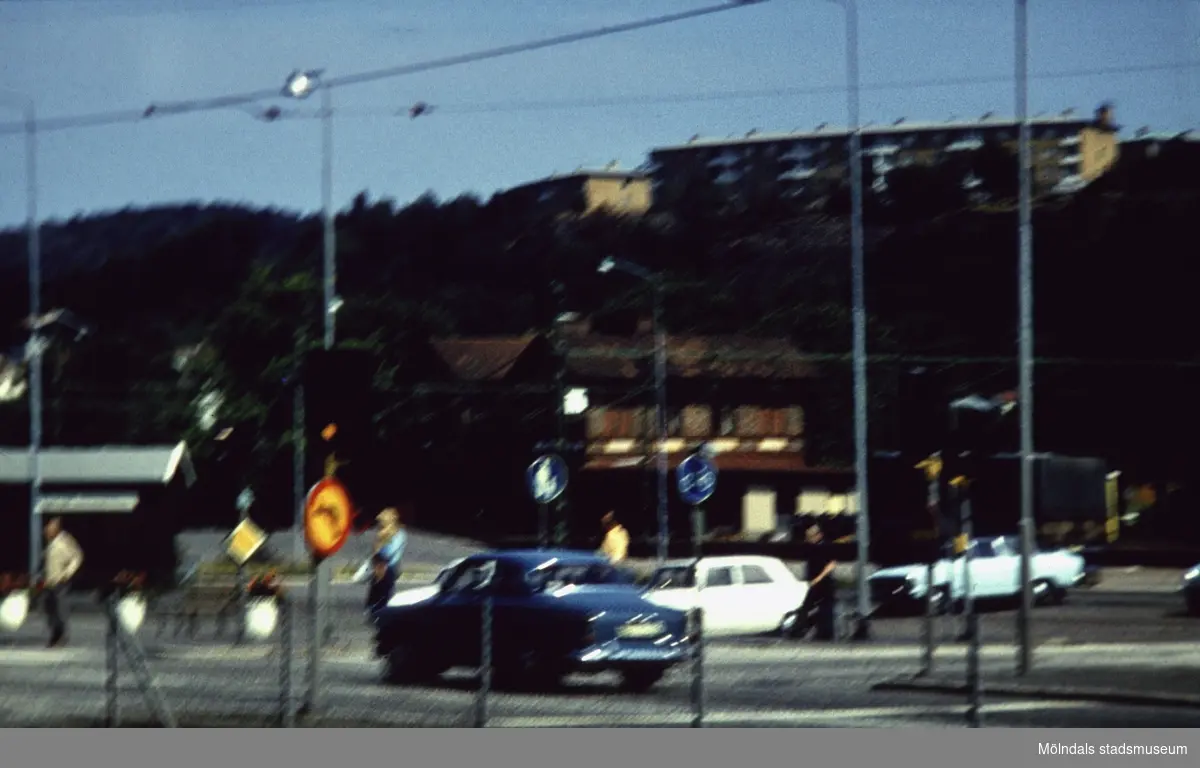Järnvägsstationen Mölndals Nedre vid Järnvägsgatan i Mölndal, 1970-tal. I ovankant ses fastigheter vid Lövgatan och Delbancogatan.