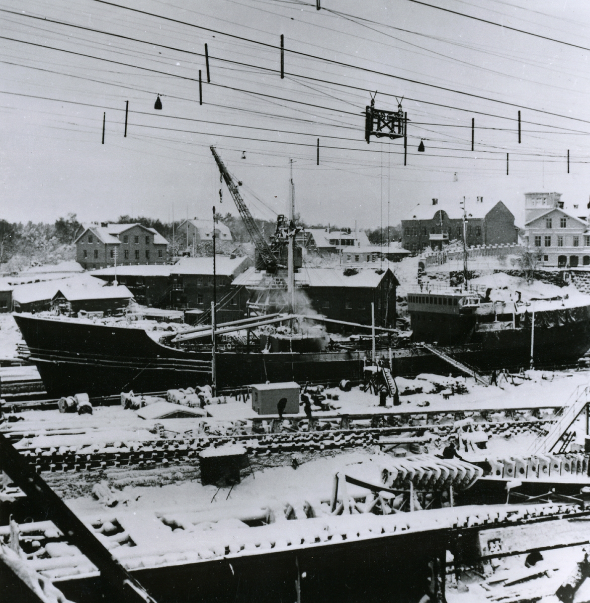 Oskarshamns varv. I dockan ligger kylmotorfartyget ÄELNOGRAD, på bädd kylmotorfartygen POLESK och MAGADAN, den 23.12.1955 efter snöfall.