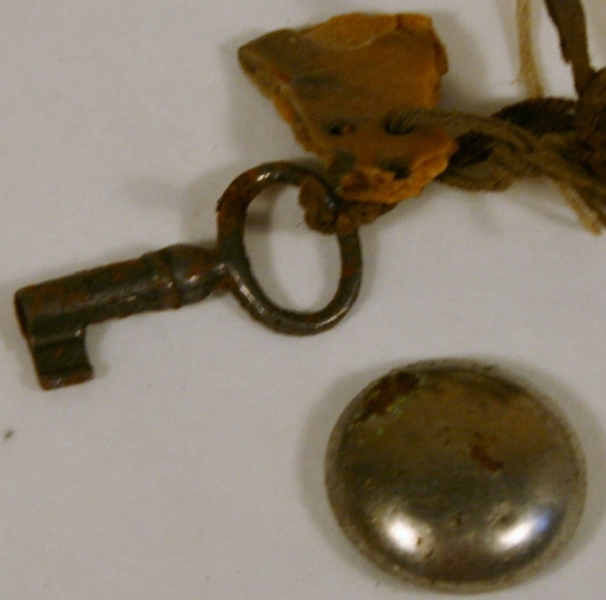 Konvolutt med fangebeslag. Innholdsfortegnelse: 1 nøkkel, 1 jernknapp og en del av plastknapp (borte)