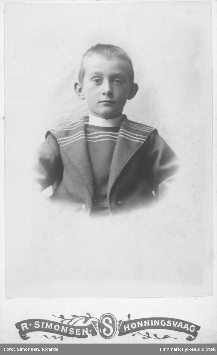Portrett av en gutt barn kledd i en mørk dress med lue.  Albumet med bildet kommer fra Ekkerøy, kanskje han kommer derfra.