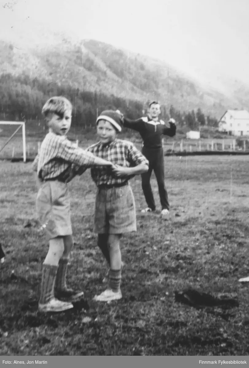 Gutter leker på Vassdal stadion i Øksfjord. Fra venstre: Gunnar Pettersen, Torfinn Kiil. Ukjent person i bakgrunnen, han ser ut til å varme opp før trening