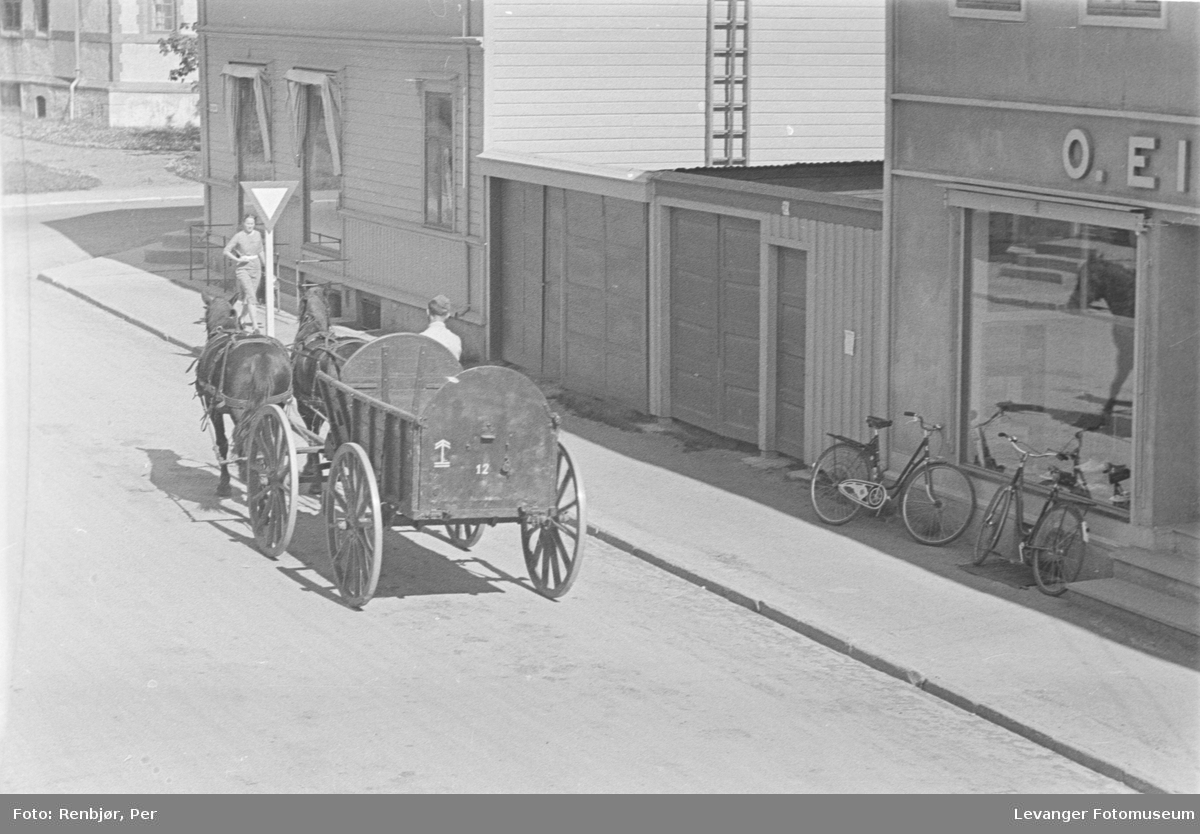 Tyske soldater med hest og vogn passerer O. Eikrems butikk i sentrum av Levanger