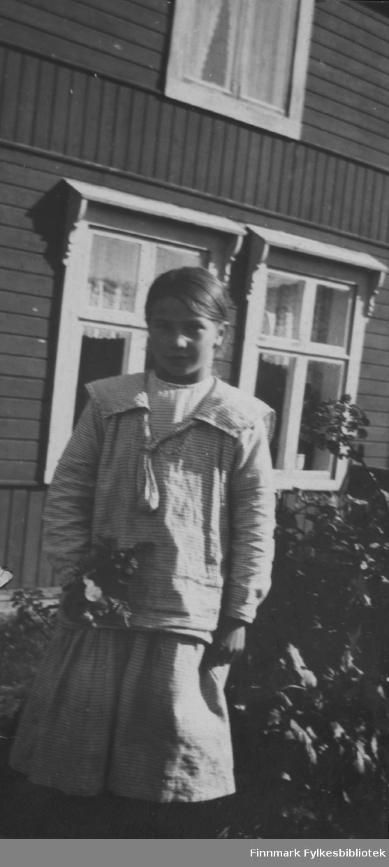 Fotografi av Aino Gunnari i hagen foran familien Gunnaris hus.ca.1922.