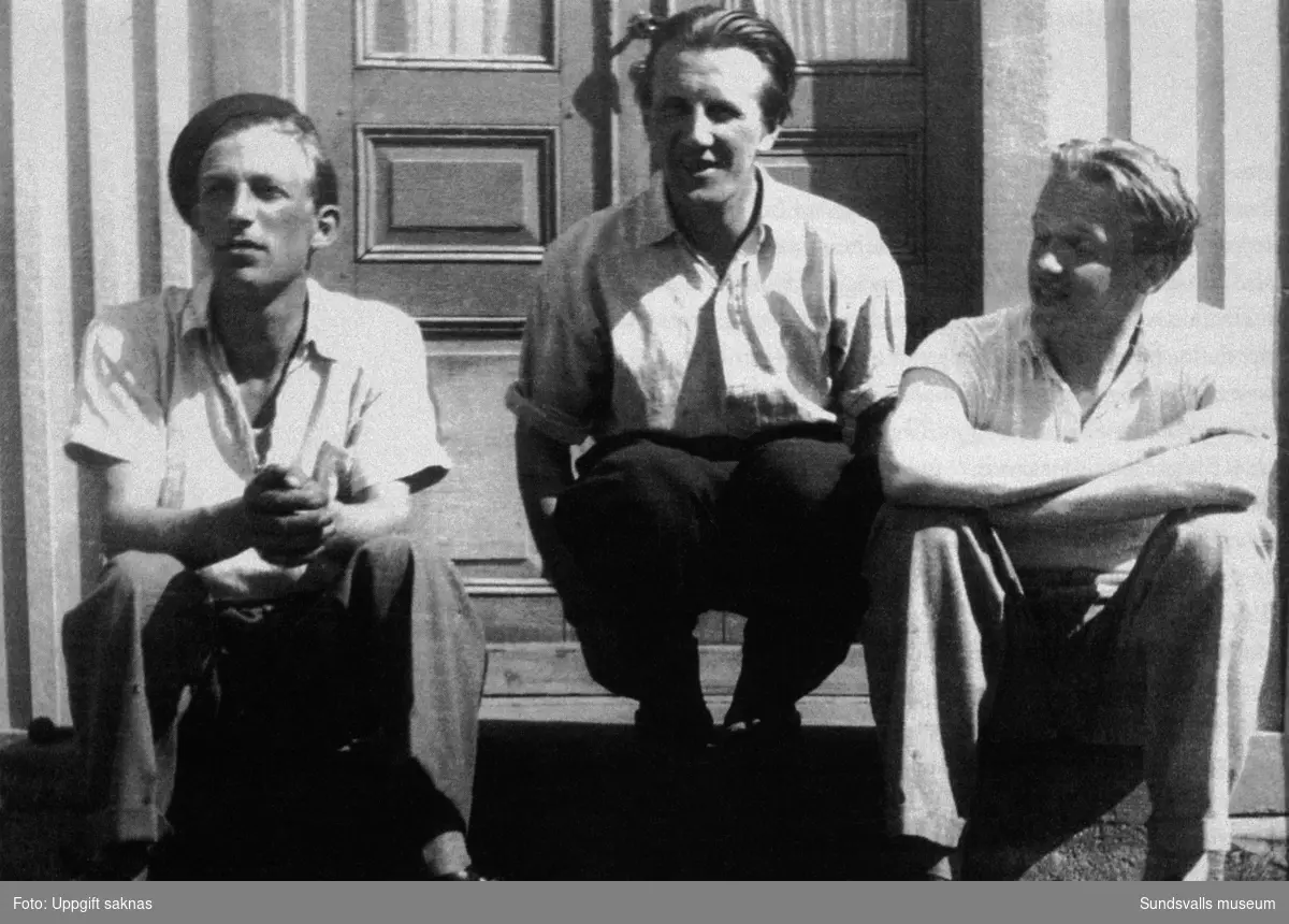 Arne Jones t v och Lars Ahlin t h på trappen till ett hus i Anundsjö. Mannen i mitten heter Nils Kristoffersson och var ägare till huset.