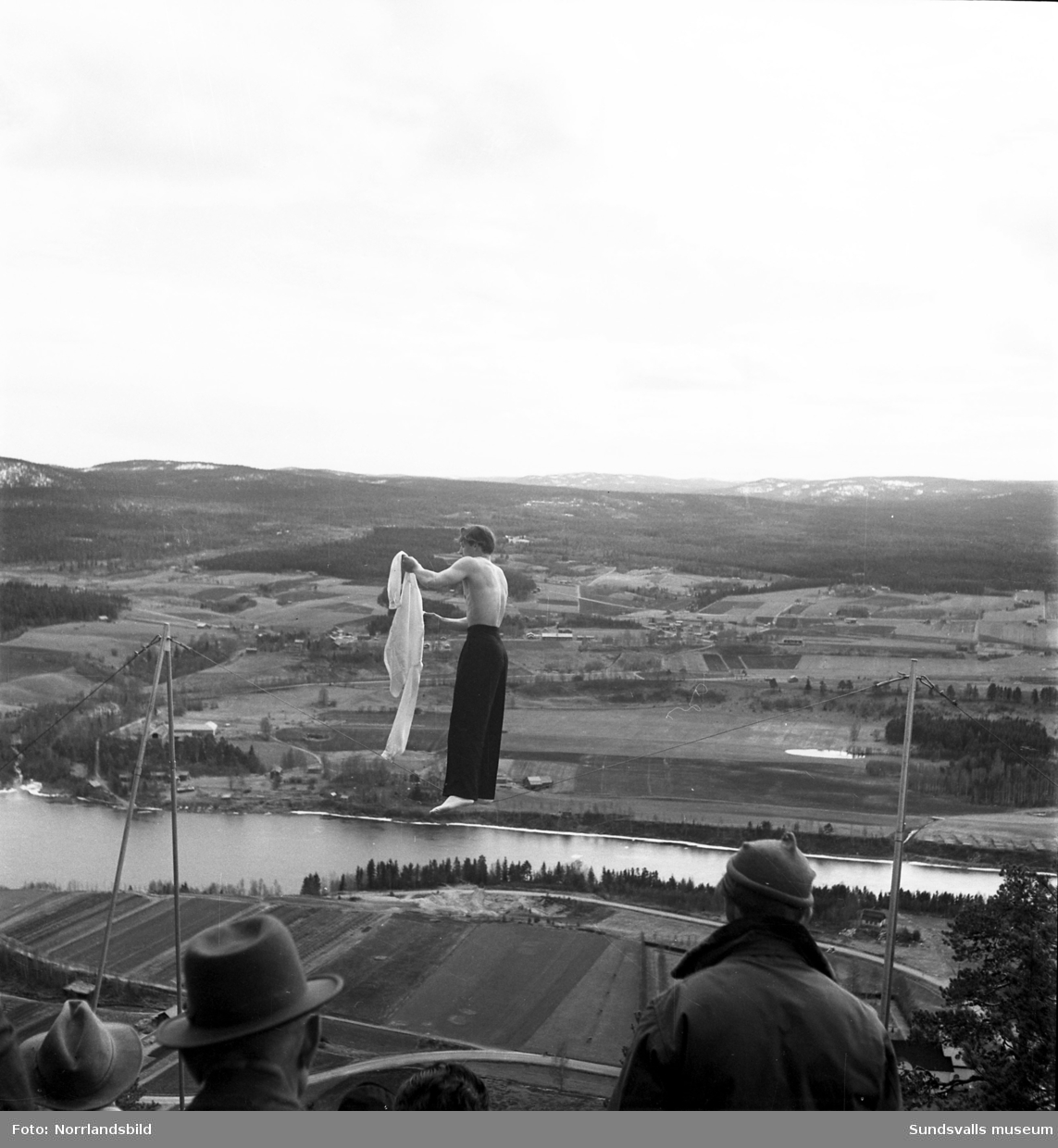 Reportagebilder av lindansaren Sture Källman, alias Max Morris, som gör ett avklädningsnummer på slak lina uppe på Multråberget i Sollefteå.